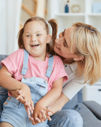 Dziewczynka z Zespołem Downa w objęciach kobiety